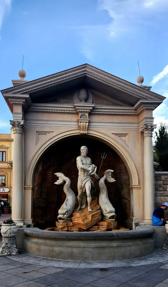 Fuente con esculturas clásicas bajo un arco ornamentado