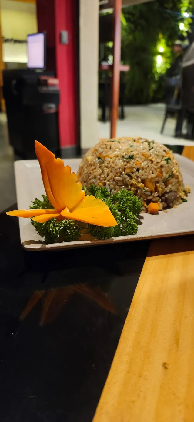 Plato de arroz frito decorado con una flor de mango