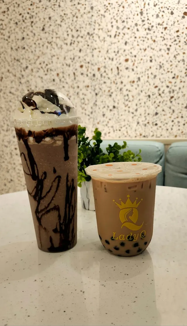 Bebida de chocolate con crema junto a un té con perlas